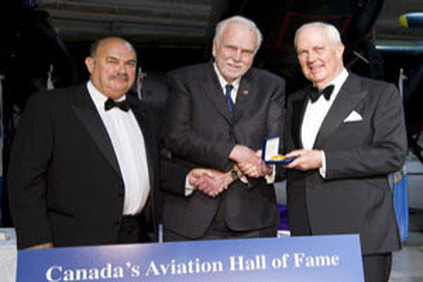 John Timmins of Toronto, ON, centre, was one of the first four pilots hired by Hollinger Ungava Transport, a special purpose airline that operated from 1948-54 to support construction of the Quebec North Shore & Labrador Railroad. He is shown receiving a Belt of Orion Award for Excellence from Canada's Aviation Hall of Fame from board chairman John Holding, left, and Gerald Haddon, right.